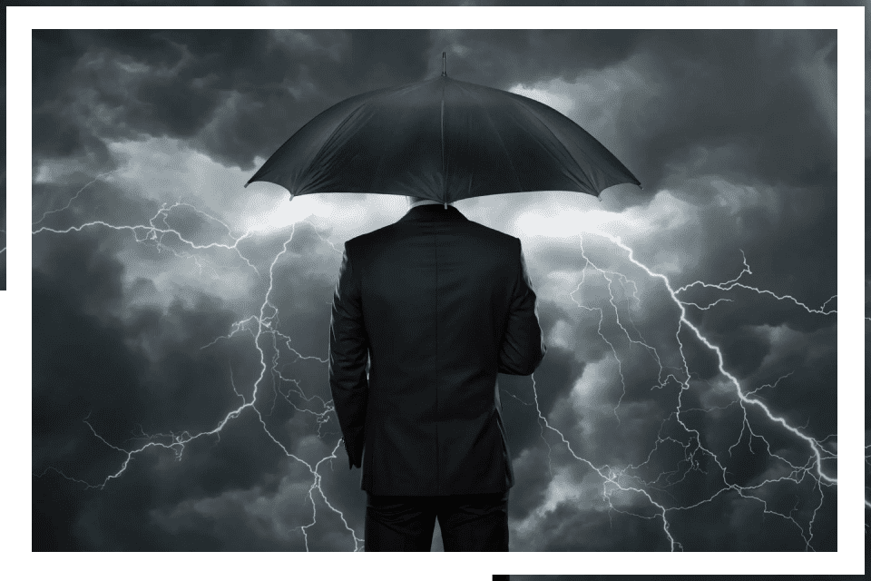 Here's an 8-word alt tag for the image: Businessman sheltered from storm with umbrella.